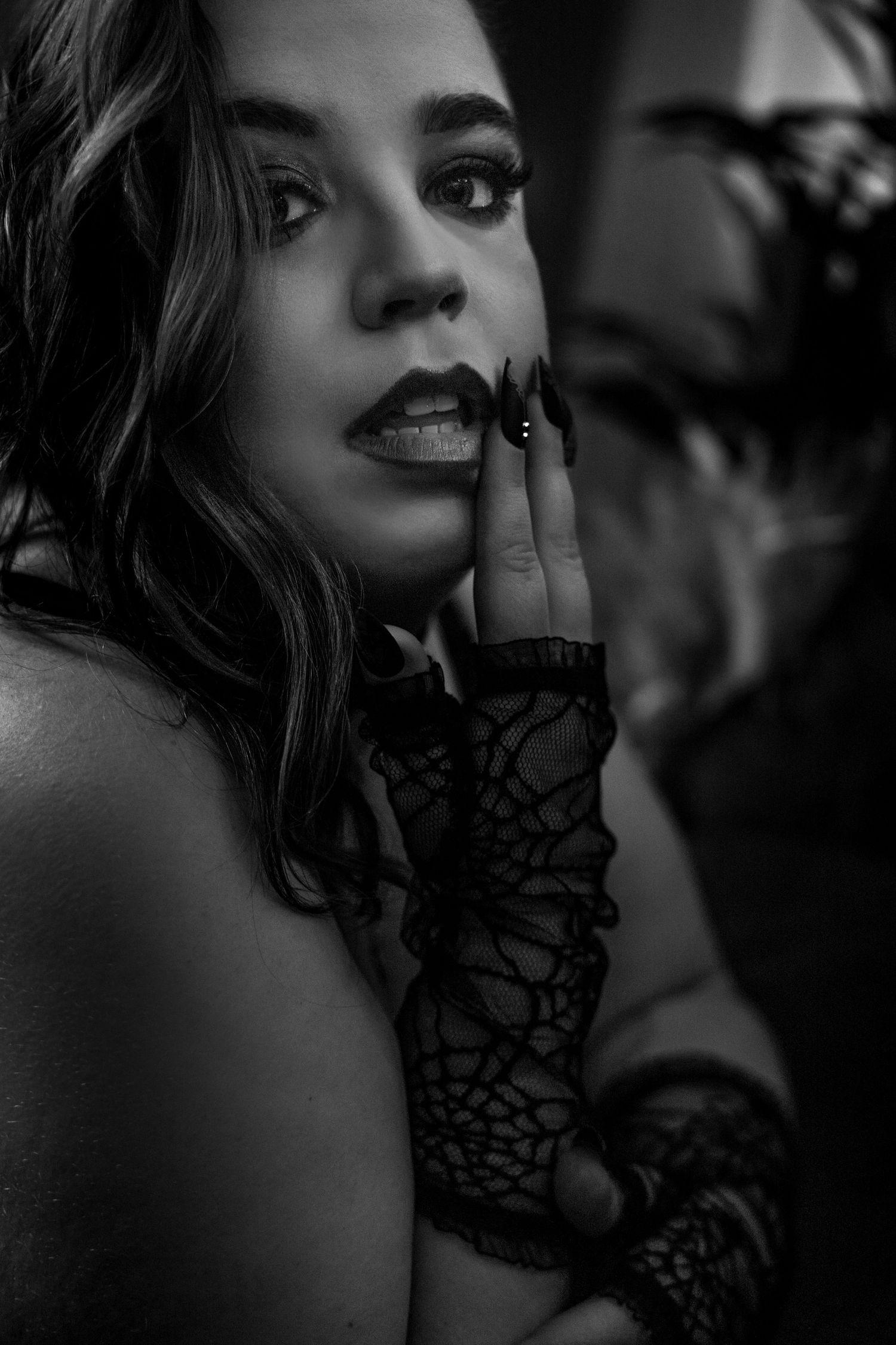 Black and white portrait with lace gloves and dramatic shadows.