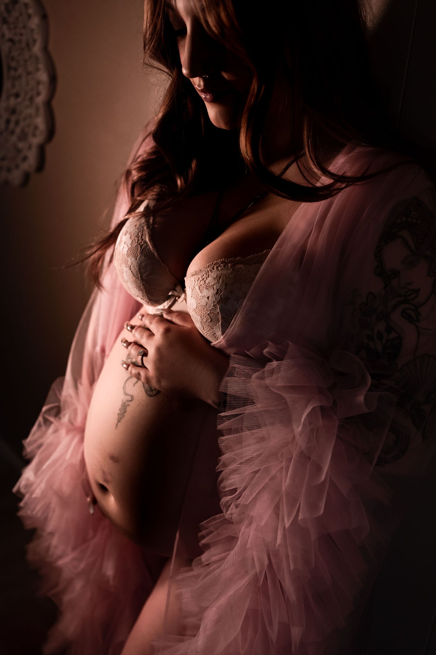 Artistic boudoir photo featuring pink tulle and lace lingerie in soft lighting.