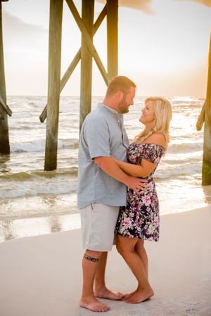 couple in front of pier during engagement photoshoot in Panama City Beach Florida