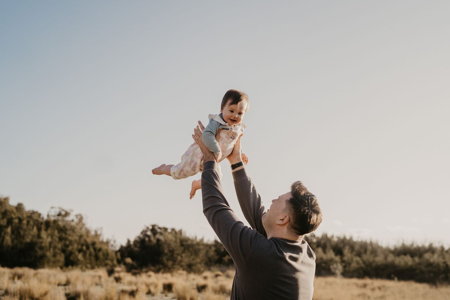 Joyful moment captured of playful interaction outdoors during sunset.