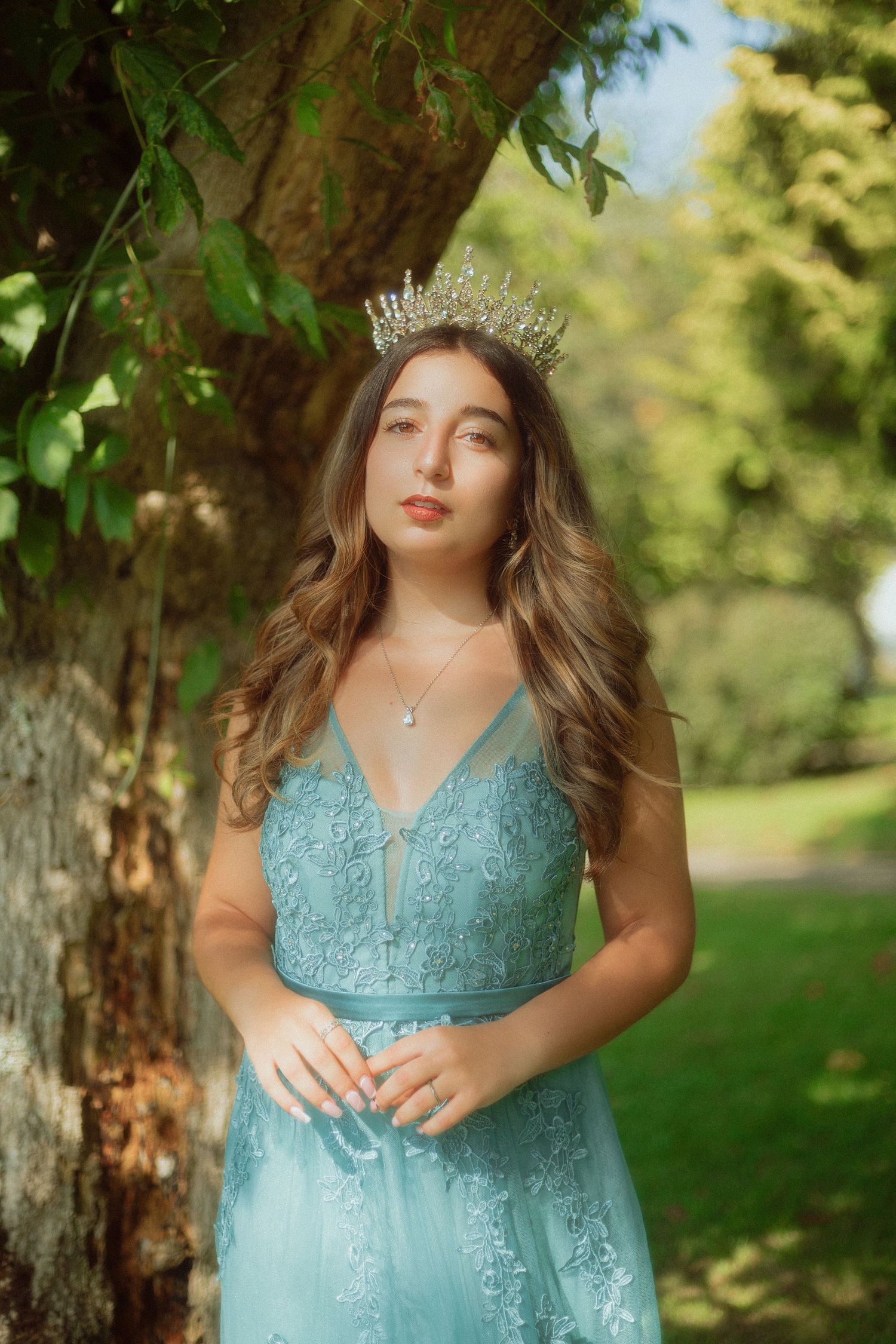 mulher princesa de vestido azul e coroa em jardim com luz a brilhar fantasia princesscore