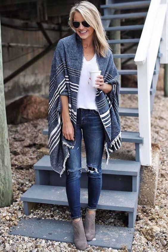 Casual winter style with striped poncho, white tee, distressed jeans and gray ankle boots.