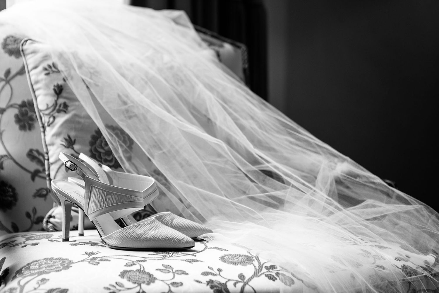 black and white detail of wedding shoes and veil