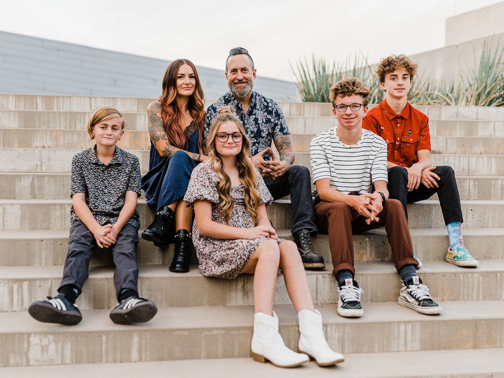 Family sitting together on concrete steps outdoors.