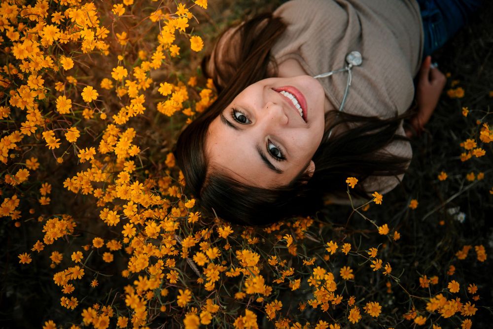Portrait series in a field of bright orange wildflowers during golden hour.