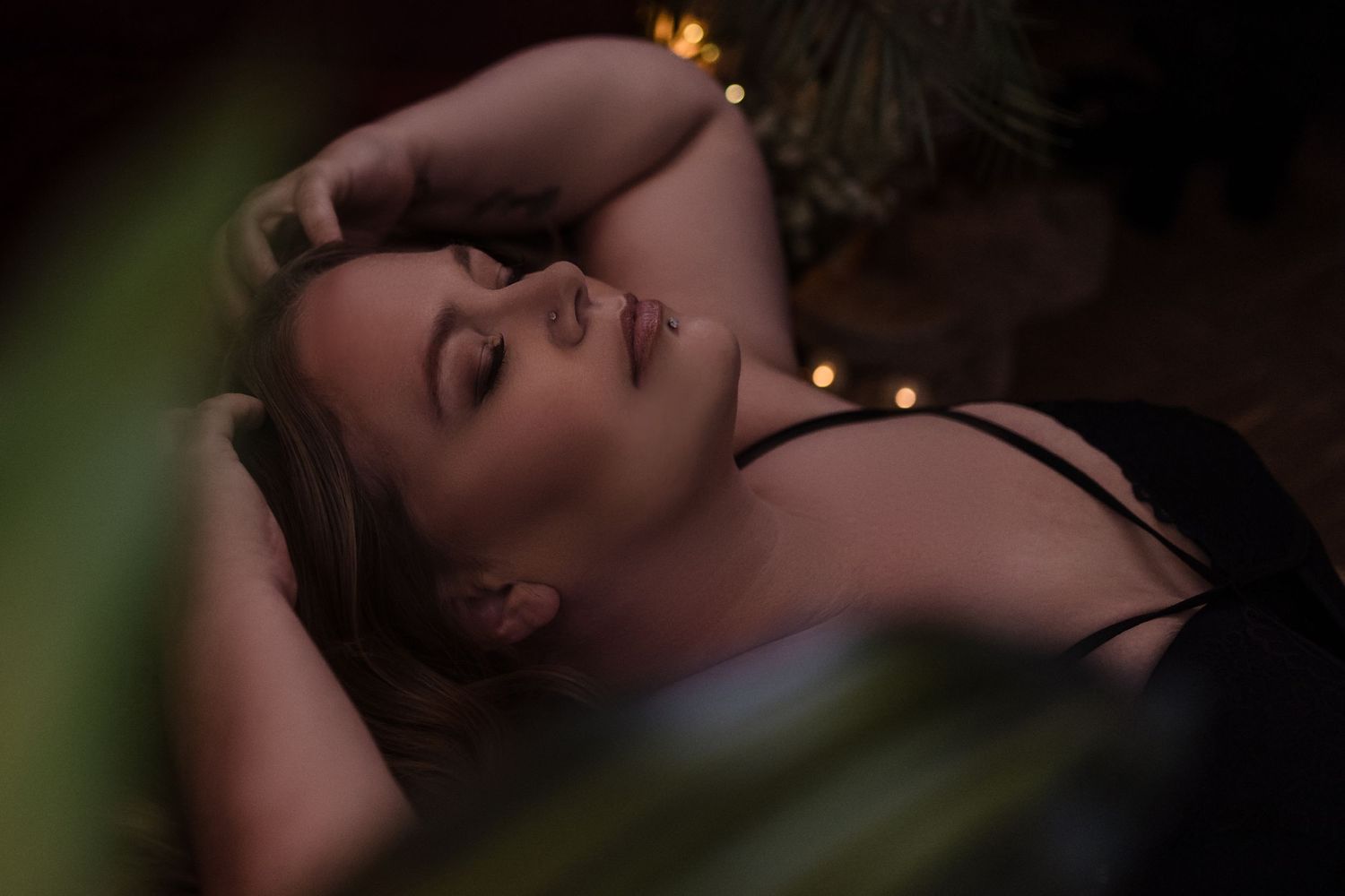 Intimate boudoir portrait with moody lighting and soft focus effects.