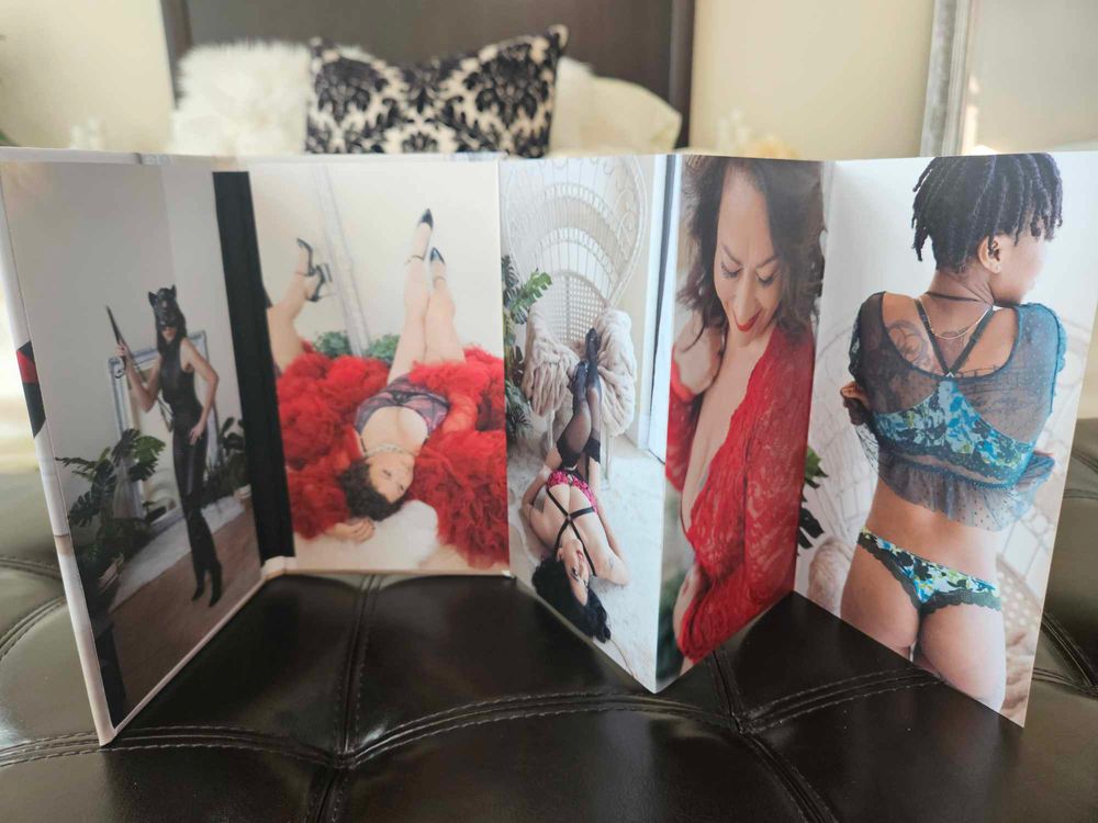 Collection of artistic photo prints displayed on a leather couch surface.