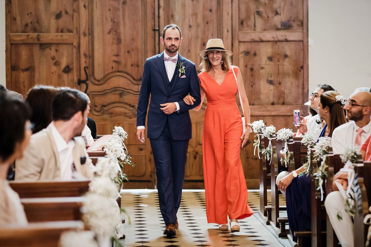 TLOOK photographe de mariage de style documentaire, Saint-Paul-de-Vence en France cérémonie à l'église le marié entre avec la maman