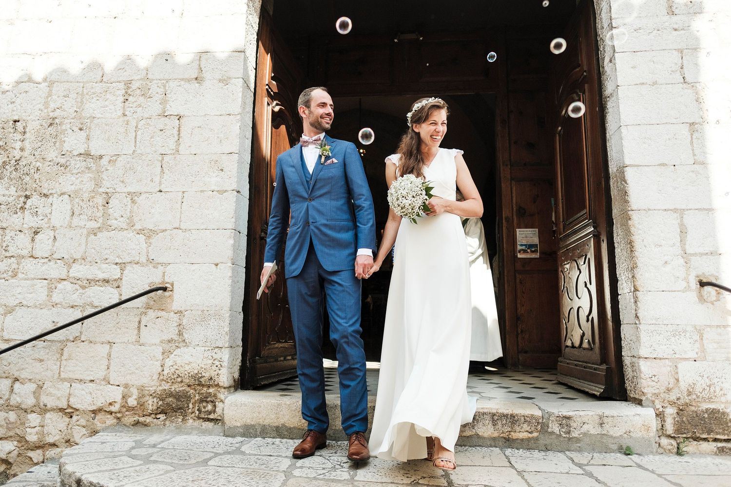 TLOOK photographe de mariage de style documentaire, Saint-Paul-de-Vence en France fin de la cérémonie sortie de l'église bulles