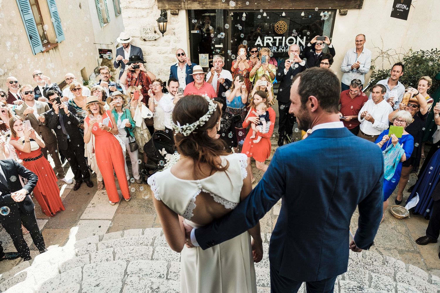 TLOOK photographe de mariage de style documentaire, Saint-Paul-de-Vence en France fin de la cérémonie sortie de l'église bulles