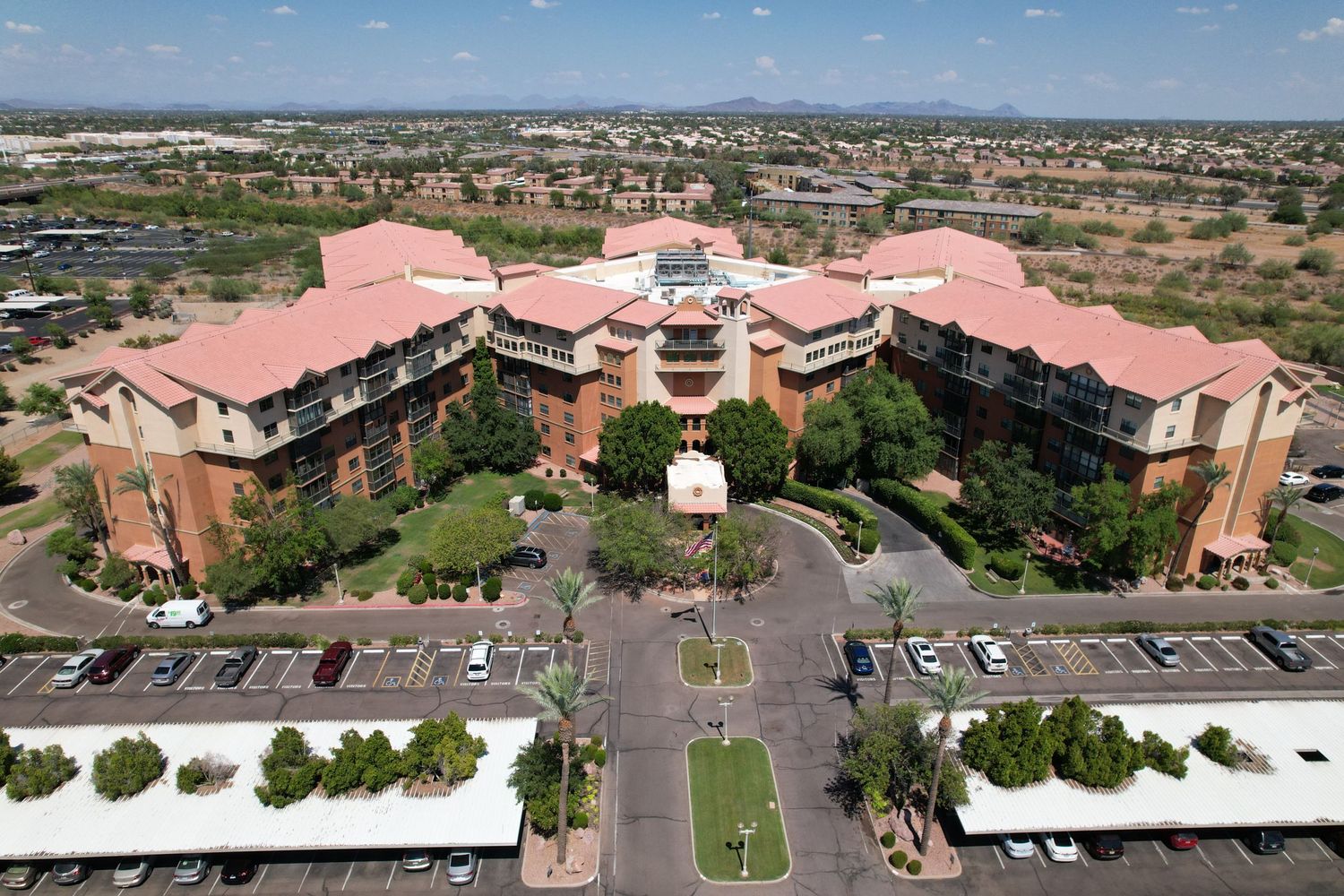 Aerial panoramic view of large pink-roofed commercial buildings and parking lots.