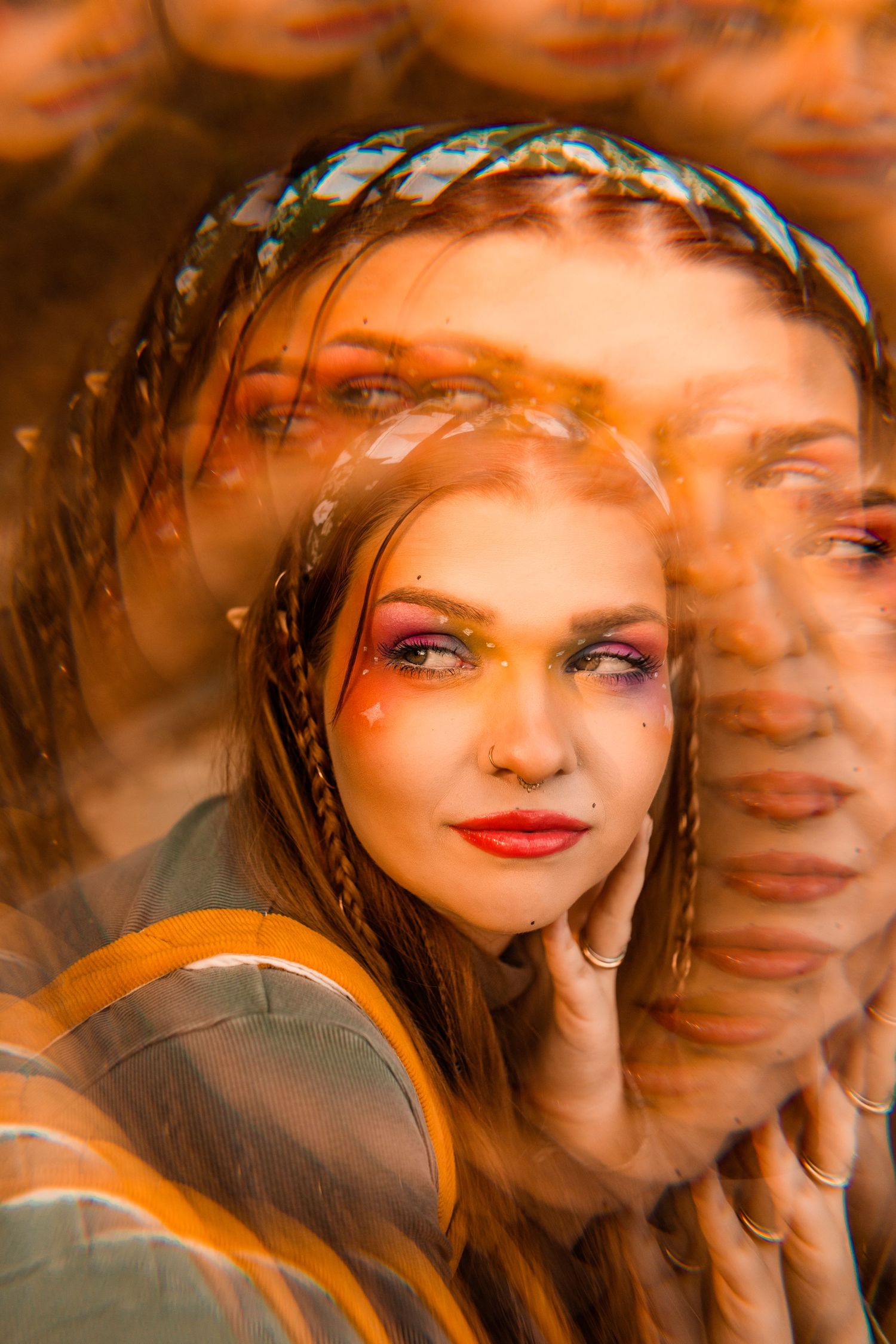 Creative double exposure portrait of a woman with colorful eye makeup and braided hair in warm tones.