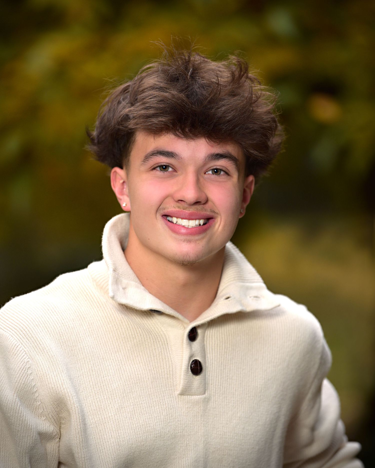Senior guy with a beige sweater on smiling.