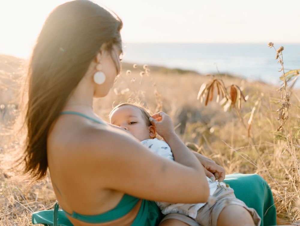 A family photoshoot by Moments With Kell on Oahu in Hawaii with mother holding her child