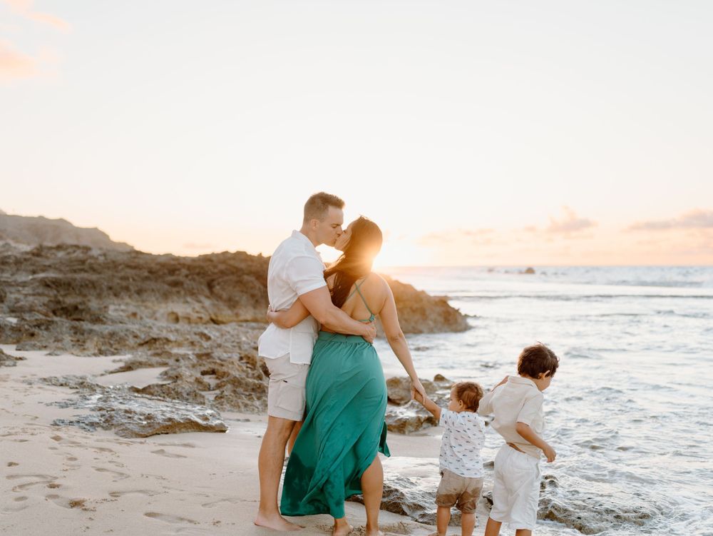 A family photoshoot by Moments With Kell on Oahu in Hawaii with parents and children playing on the beach