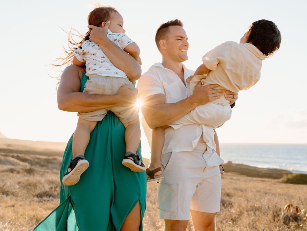 A family photoshoot by Moments With Kell on Oahu in Hawaii with parents and children playing