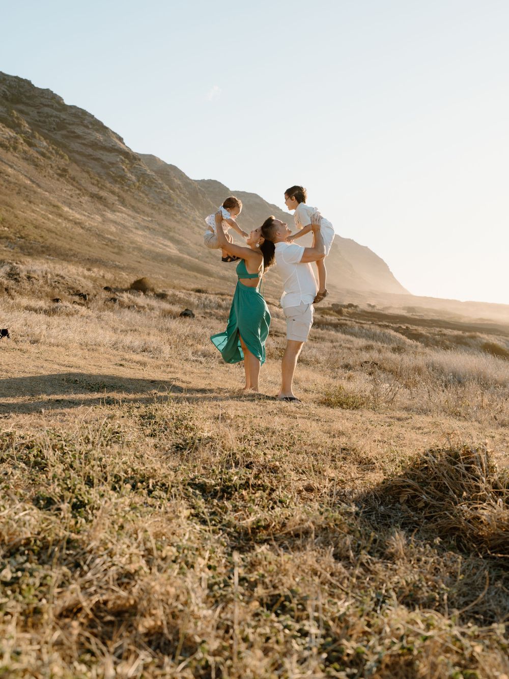 A family photoshoot by Moments With Kell on Oahu in Hawaii with parents and children playing