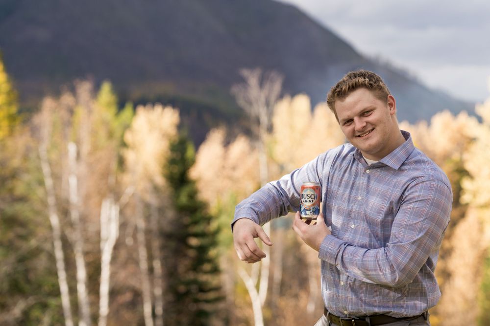 Person in a light shirt poses with a ring against a mountainous autumn backdrop.