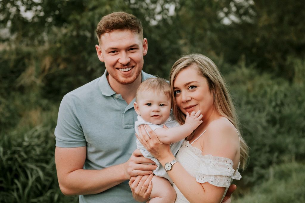 Family portrait in natural outdoor setting during golden hour.