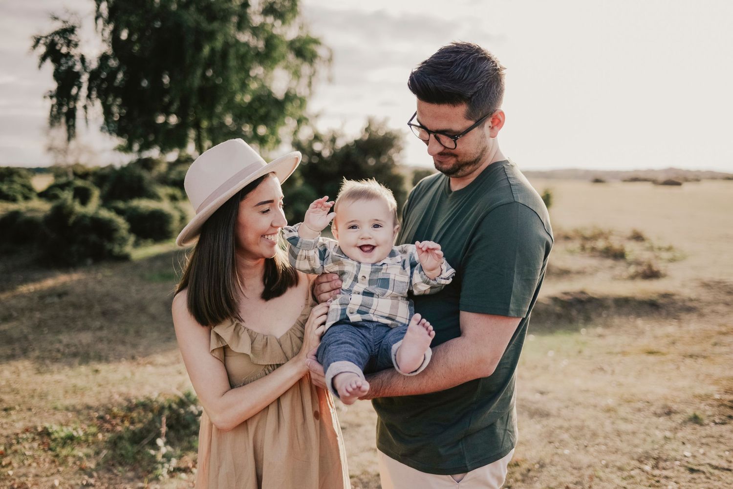 Outdoor family portrait session in casual attire against natural backdrop.