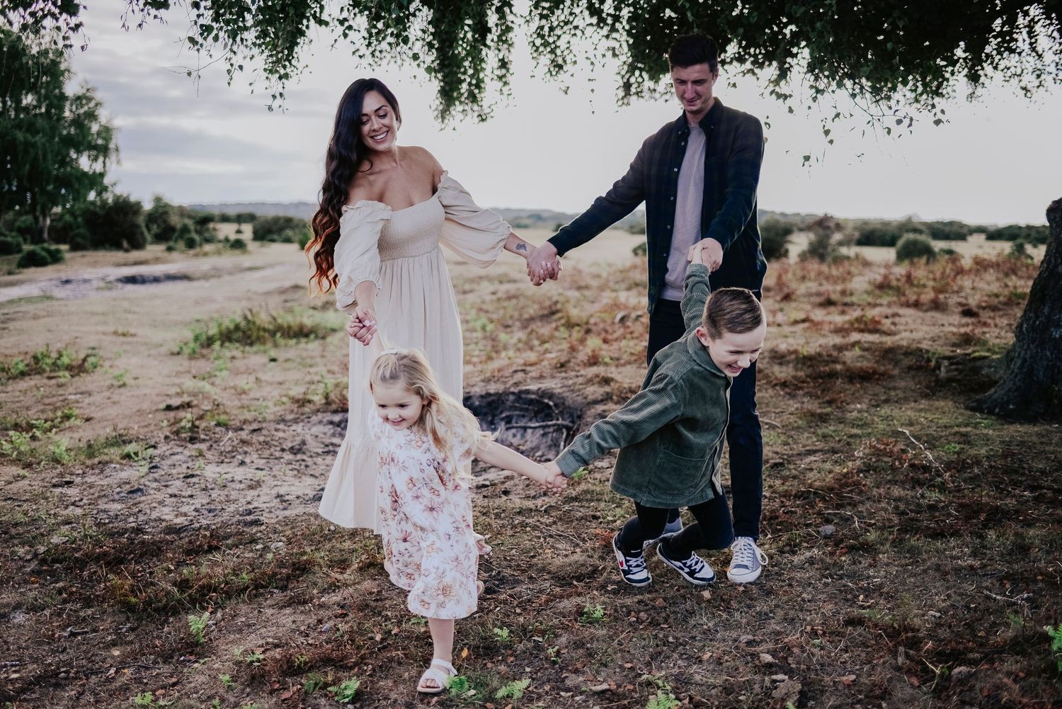 Family walking together outdoors with natural landscape in background.