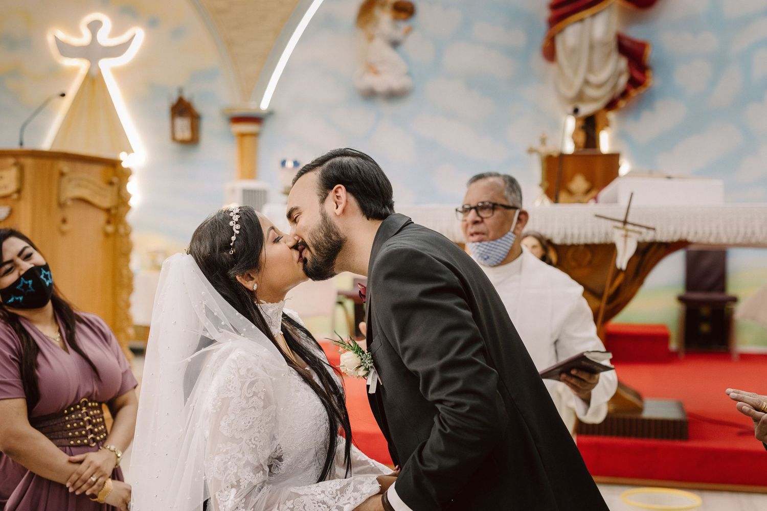 A romantic kiss during a wedding ceremony in a beautifully decorated church.