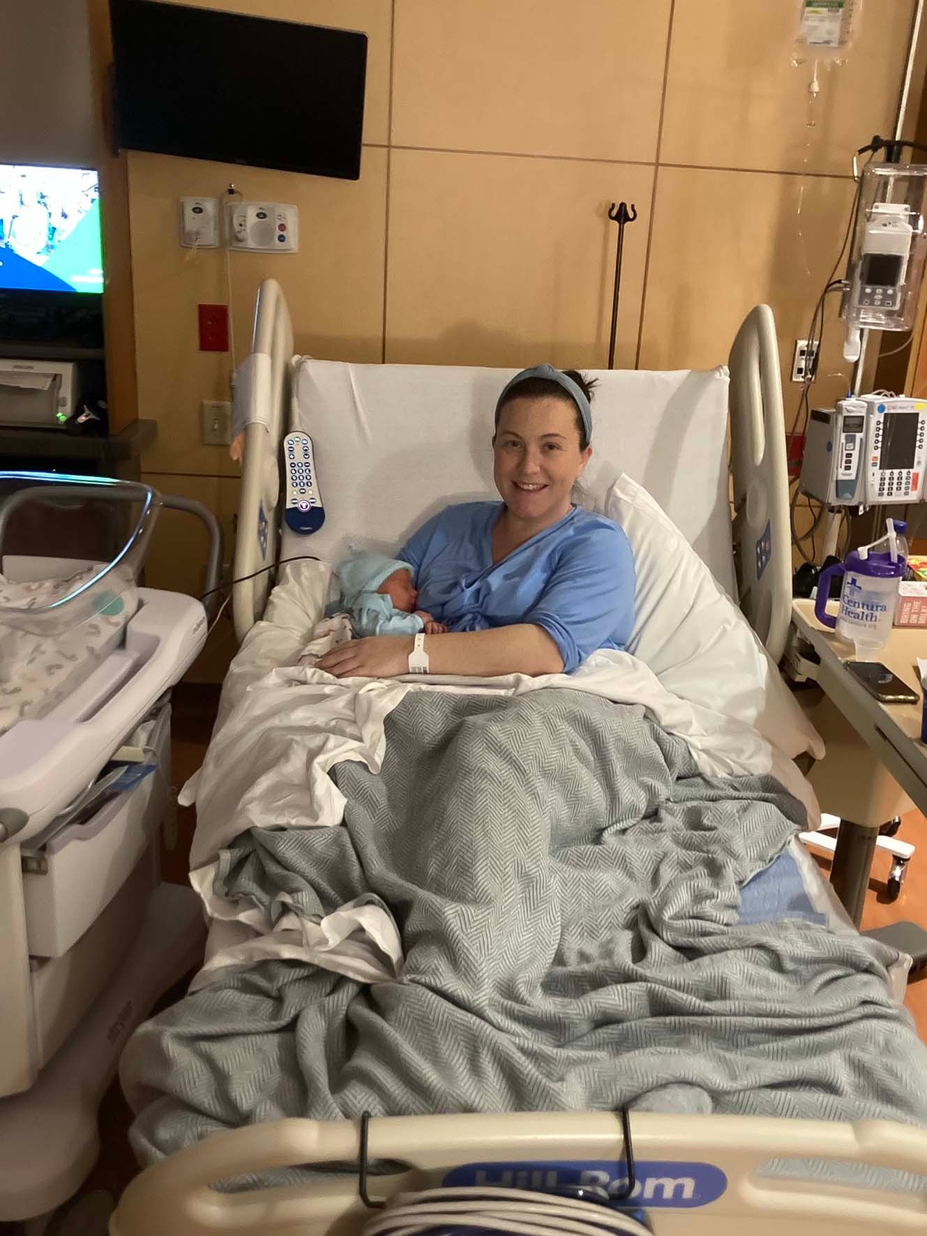 Post partum woman in hospital bed with newborn at parker adventist in parker colorado