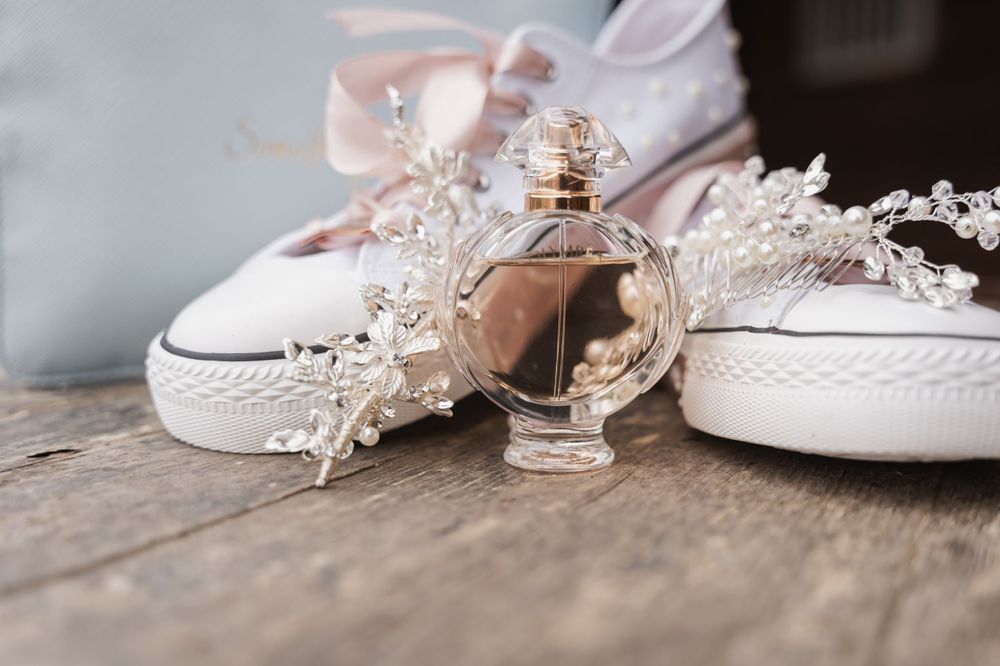 Wedding accessories including white sneakers, perfume bottle and delicate lace details.