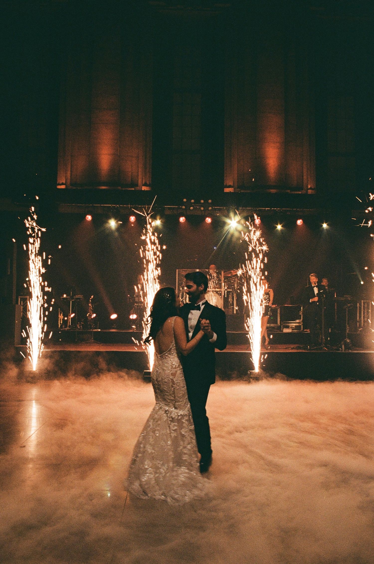 First dance with sparkler effects and fog on dark reception dance floor.