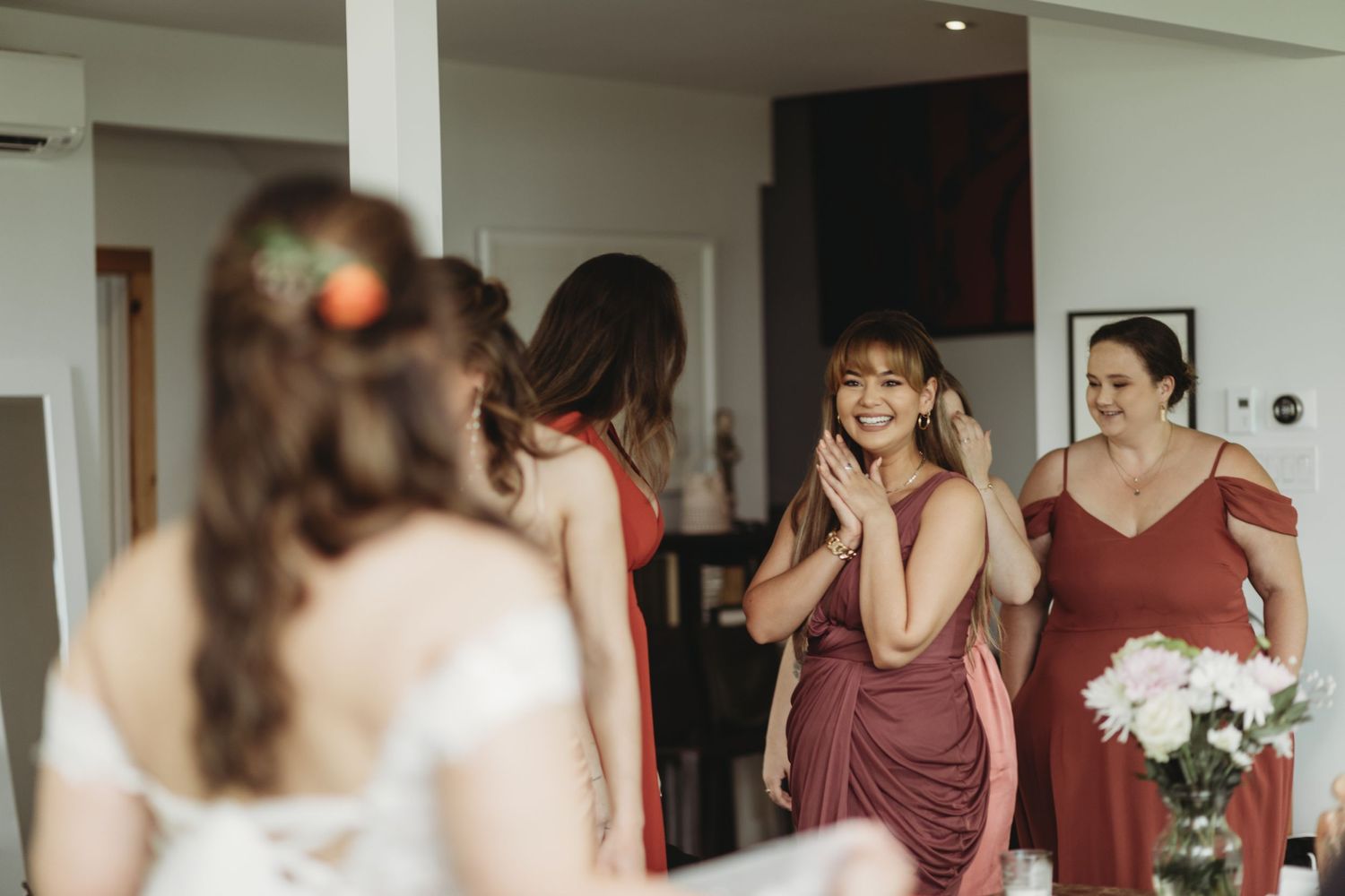 Candid moment of wedding party reaction in modern interior setting.