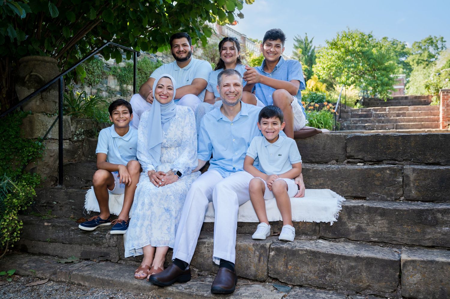 Multi-generational group posed on outdoor stone steps.