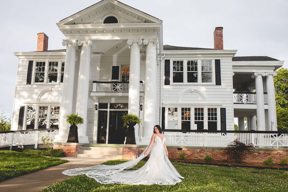 White colonial-style wedding venue exterior with multiple windows and classic architectural details.