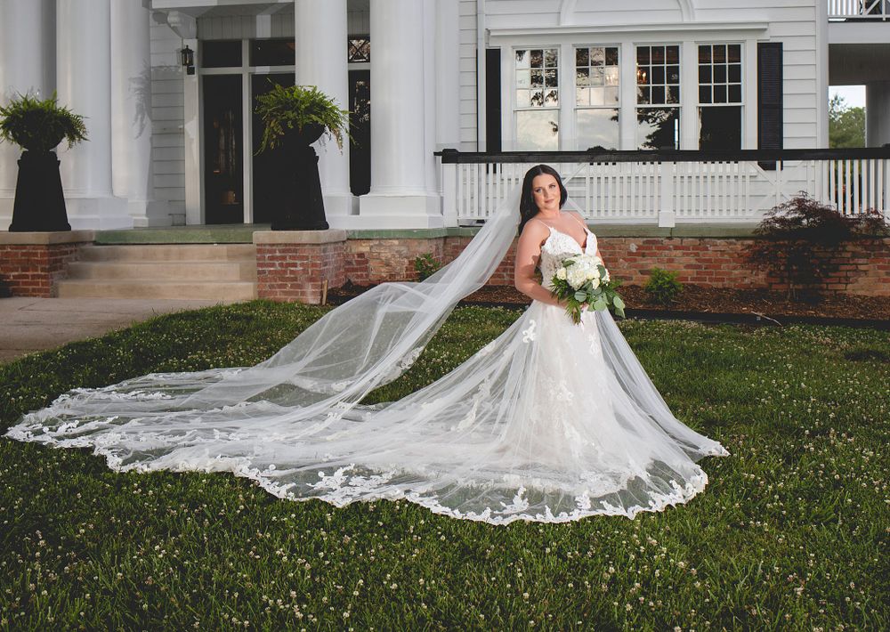 Wedding dress portraits on the lawn of a grand white colonial mansion with sweeping train details.