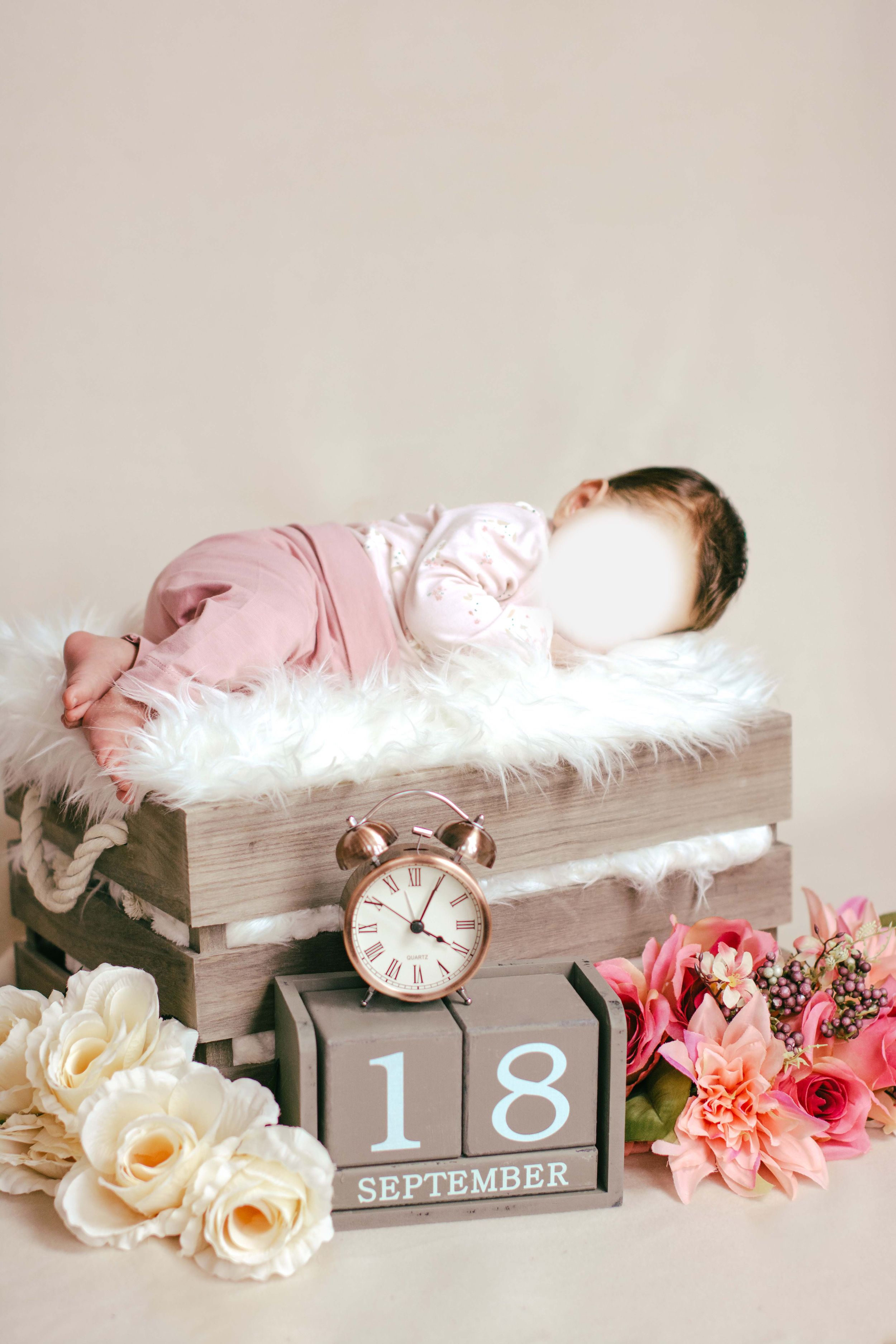 Baby liegt auf Kiste mit Blumen und Geburtsdatum und Zeit als dekoration
