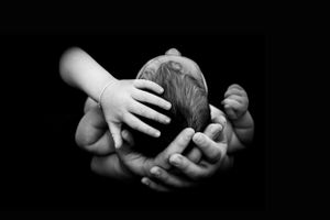 Schwarz Weiß Aufnahme mit Baby Kopf und Händen von Mutter und Schwester
