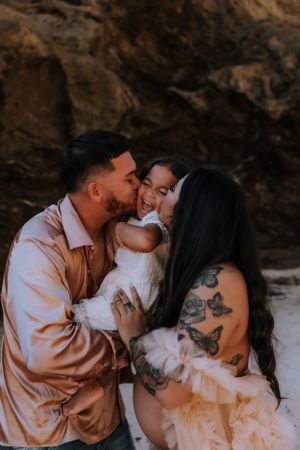 Intimate family moment captured during a beach maternity photoshoot.