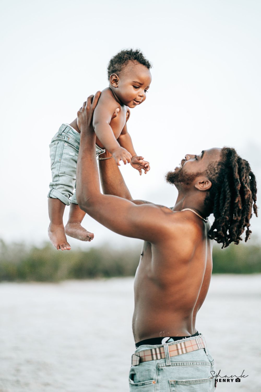 Heartwarming moment of play between parent and child at a waterfront setting.
