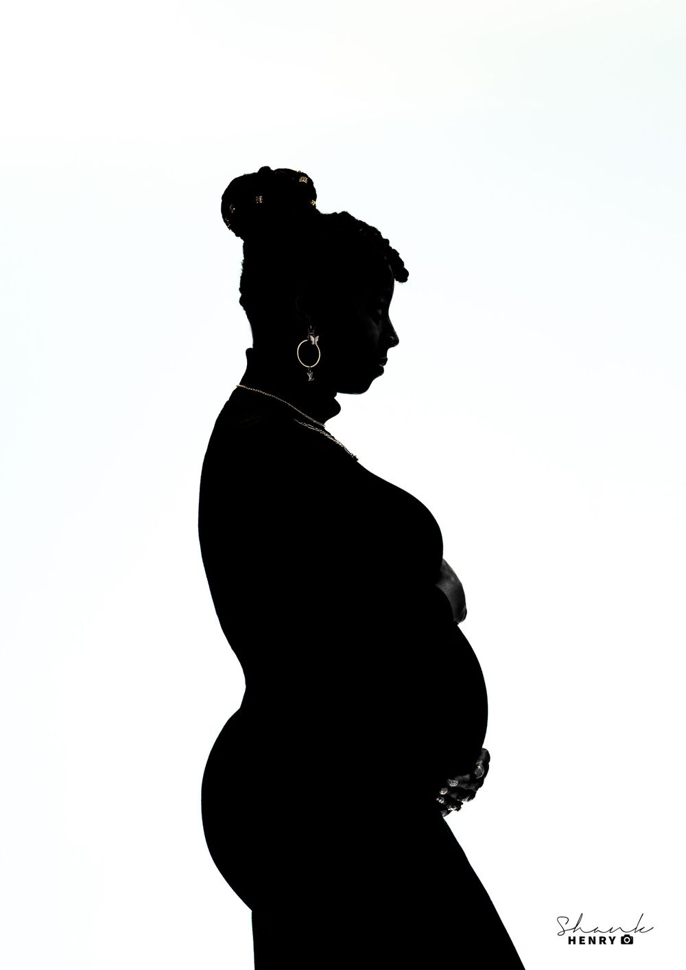 Artistic silhouette of an expectant mother in profile against a white background.