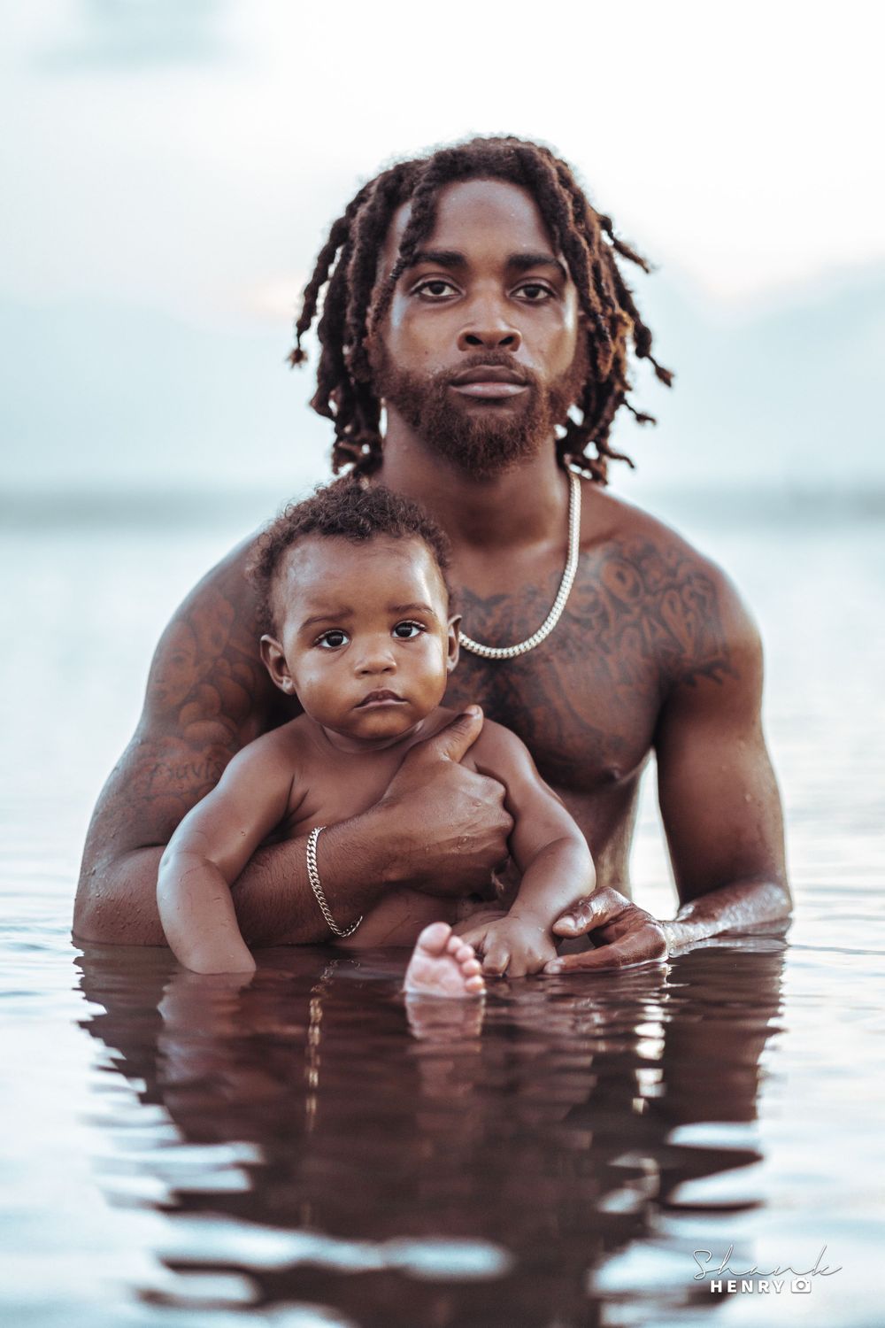 Artistic portrait in water showing tender moment between parent and baby.