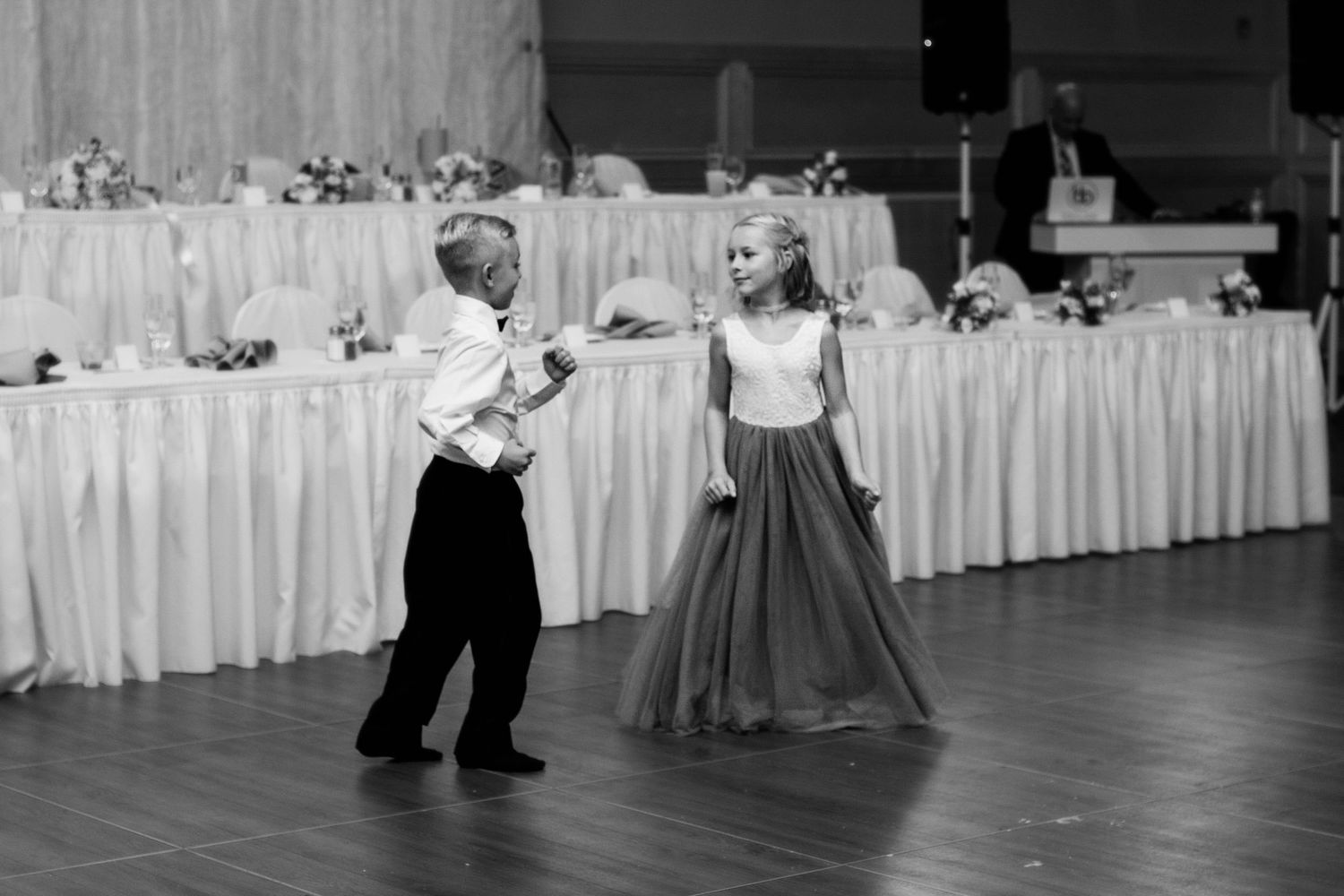 Young dancers performing at wedding reception in black and white.
