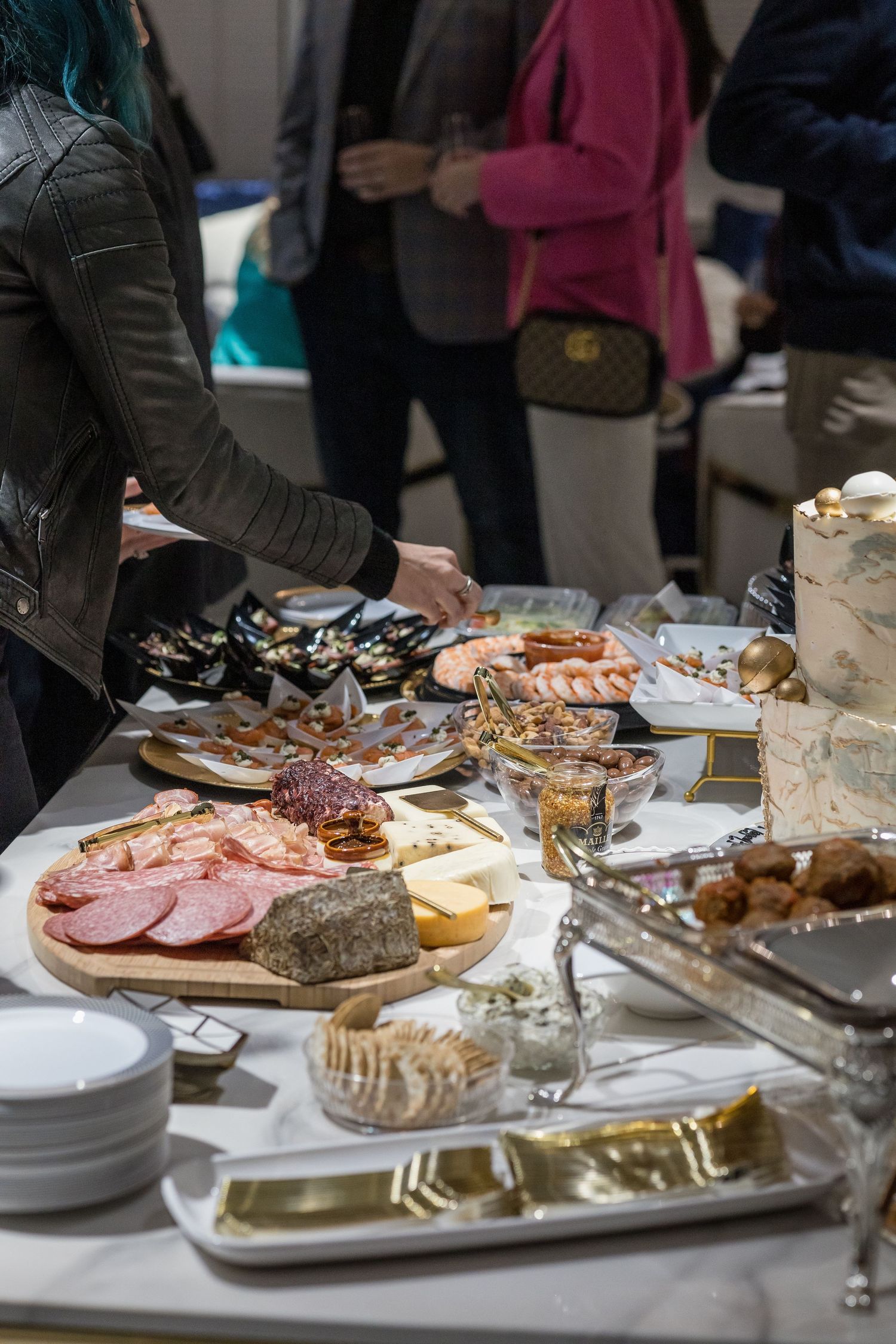 Elegant buffet spread with meats, seafood and appetizers on silver platters at an upscale event.