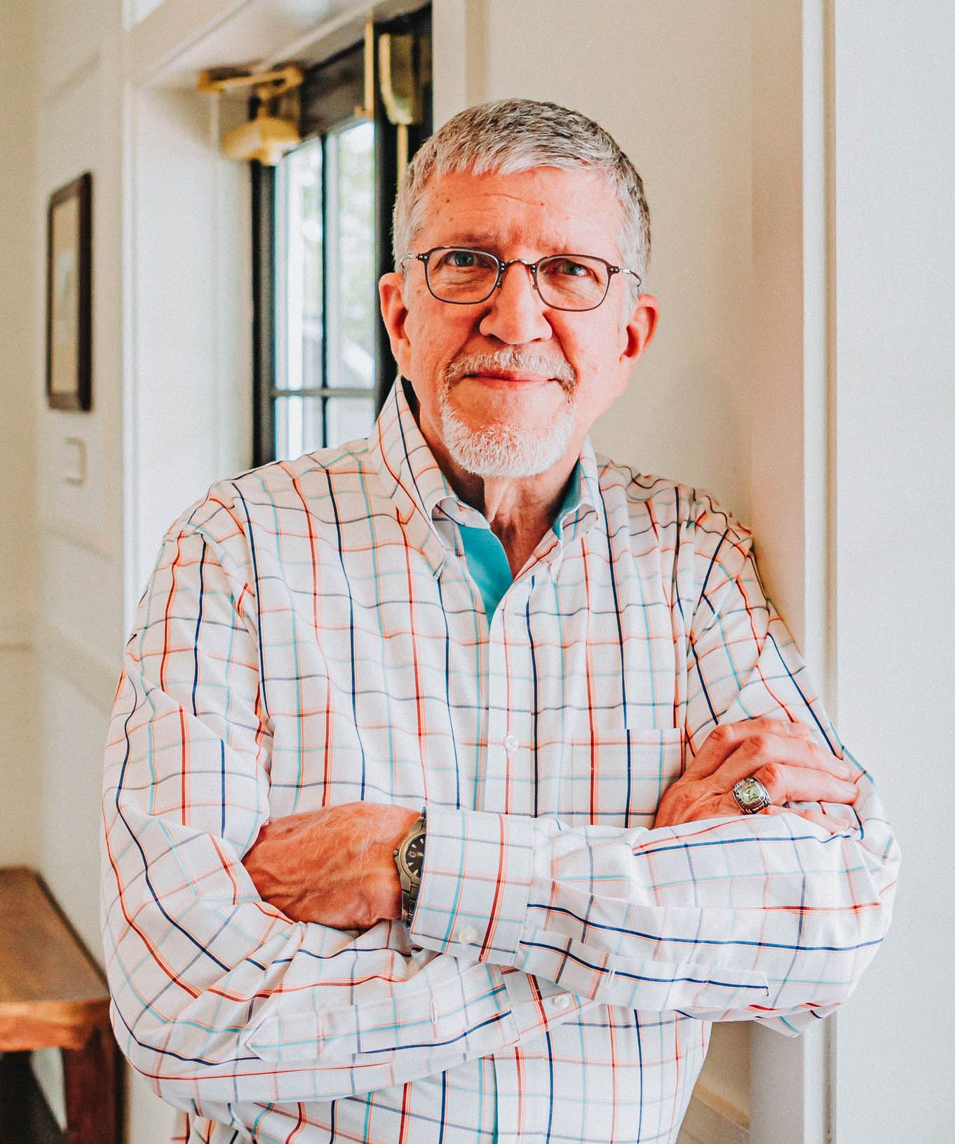 Professional portrait showing someone wearing glasses and a plaid button-down shirt.