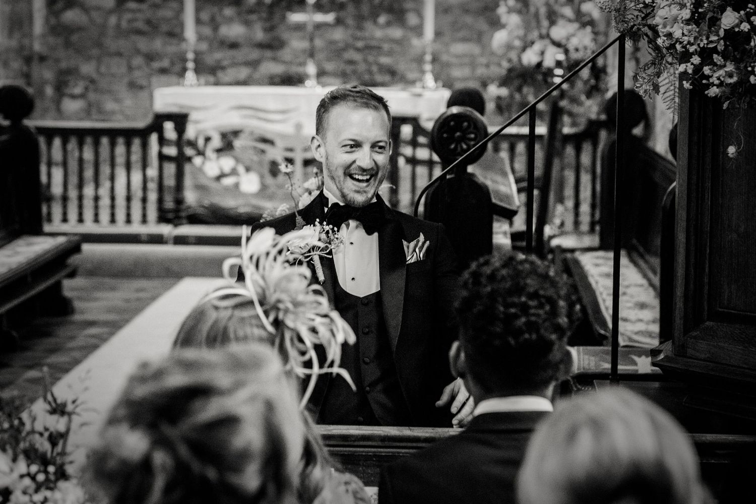 Black and white photo of wedding guests gathered outside a building.