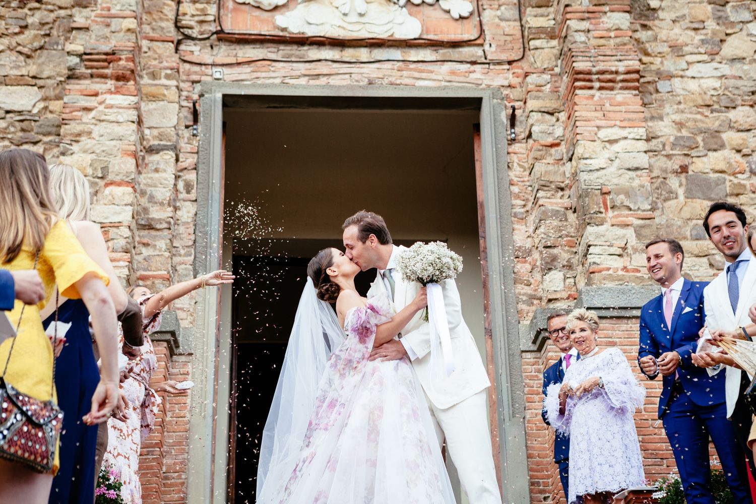 bride and groom kiss outside the church Santa Maria Assunta in Panzano Chianti Tuscany Italy