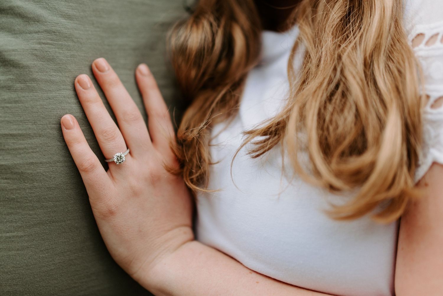 Close-up details of hands tenderly touching against a dark background.