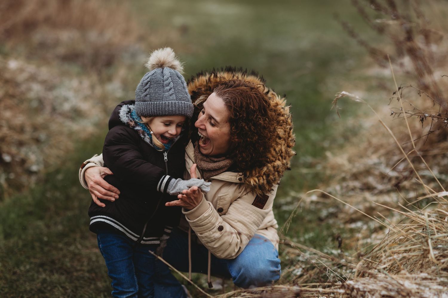 A tender moment captured outdoors between parent and child wearing winter clothes.
