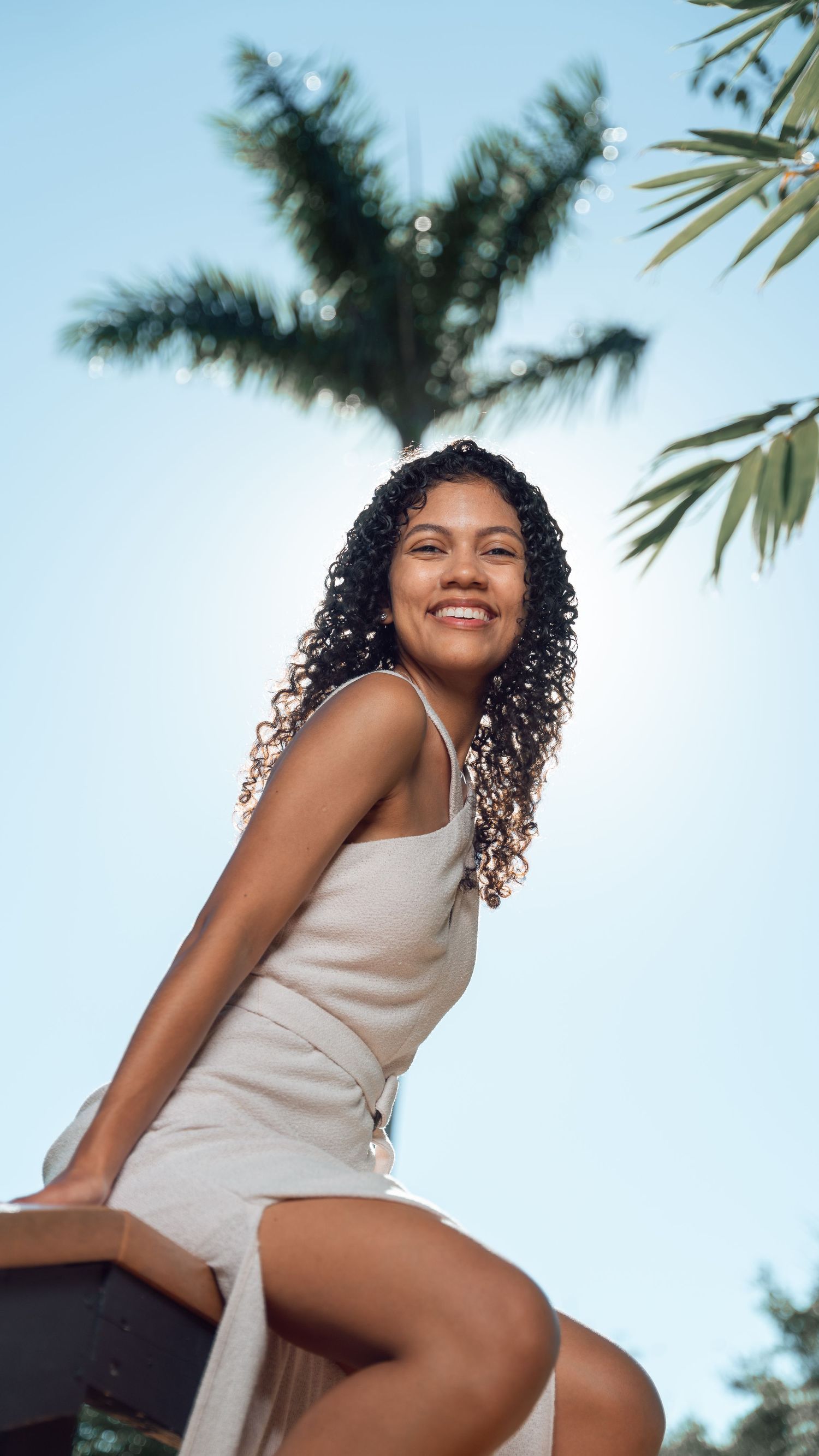 A light summer dress catching the tropical breeze under palm trees.