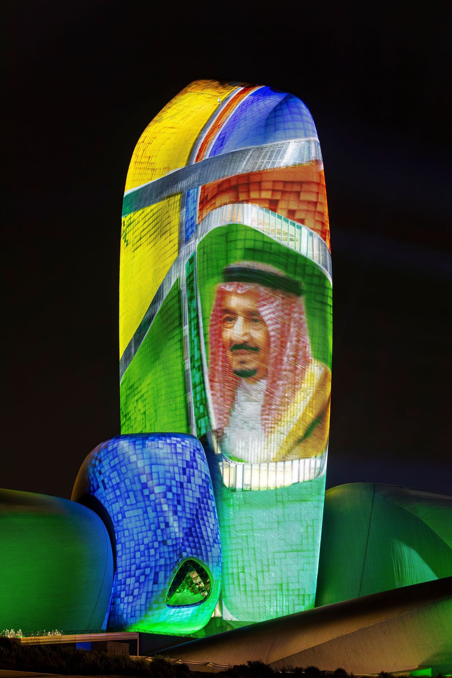 Illuminated modern architectural display featuring colorful mosaic patterns and vibrant lighting effects at night.