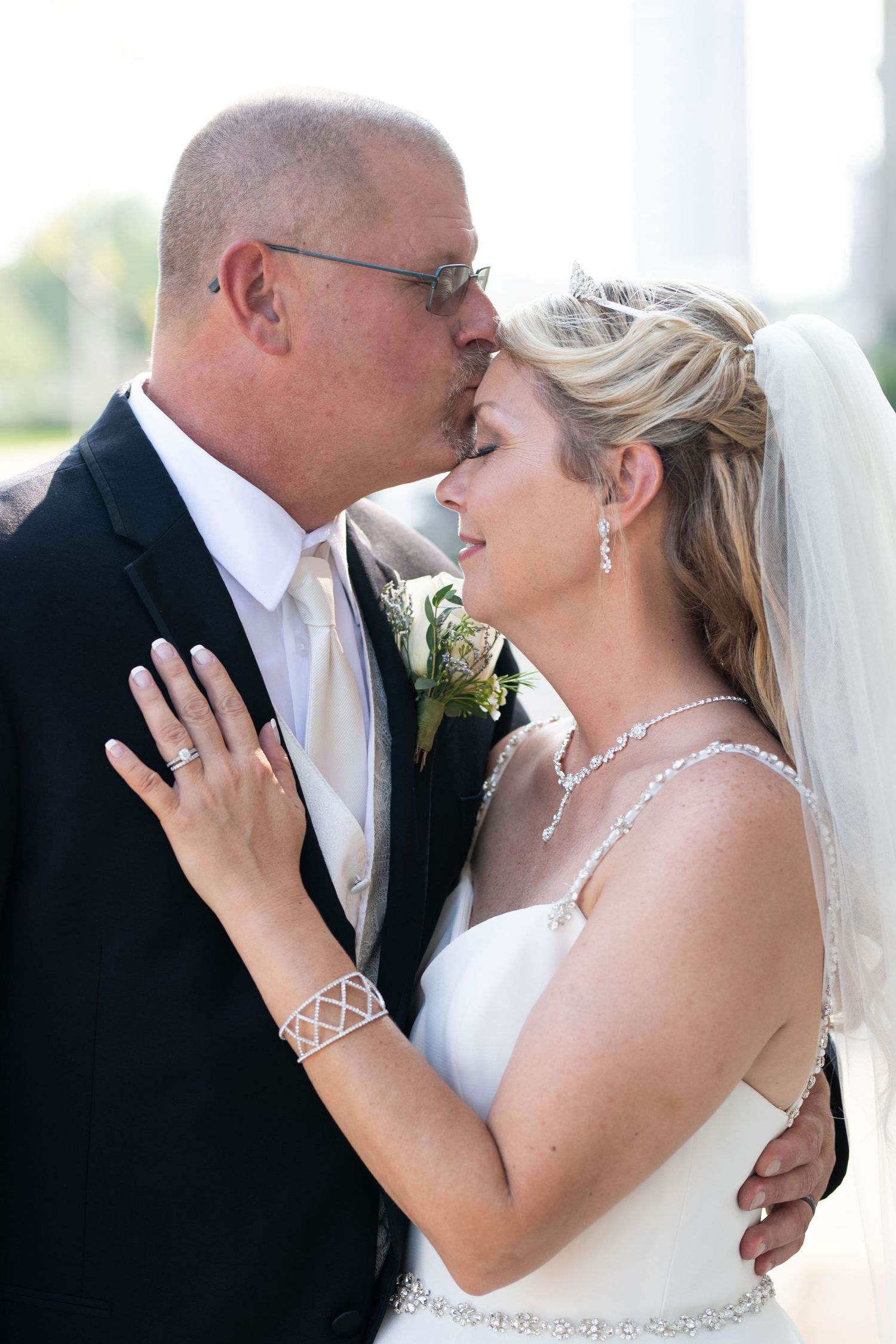Groom kissing bride on the forehead