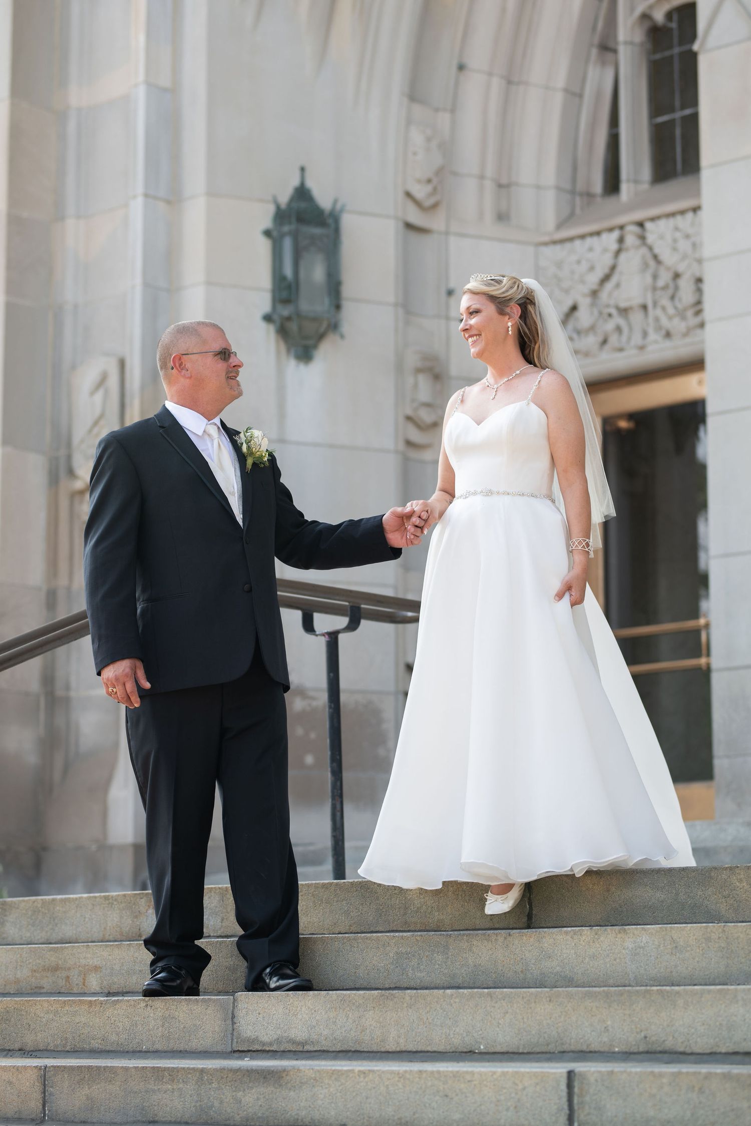 Groom leading Bride down the stars